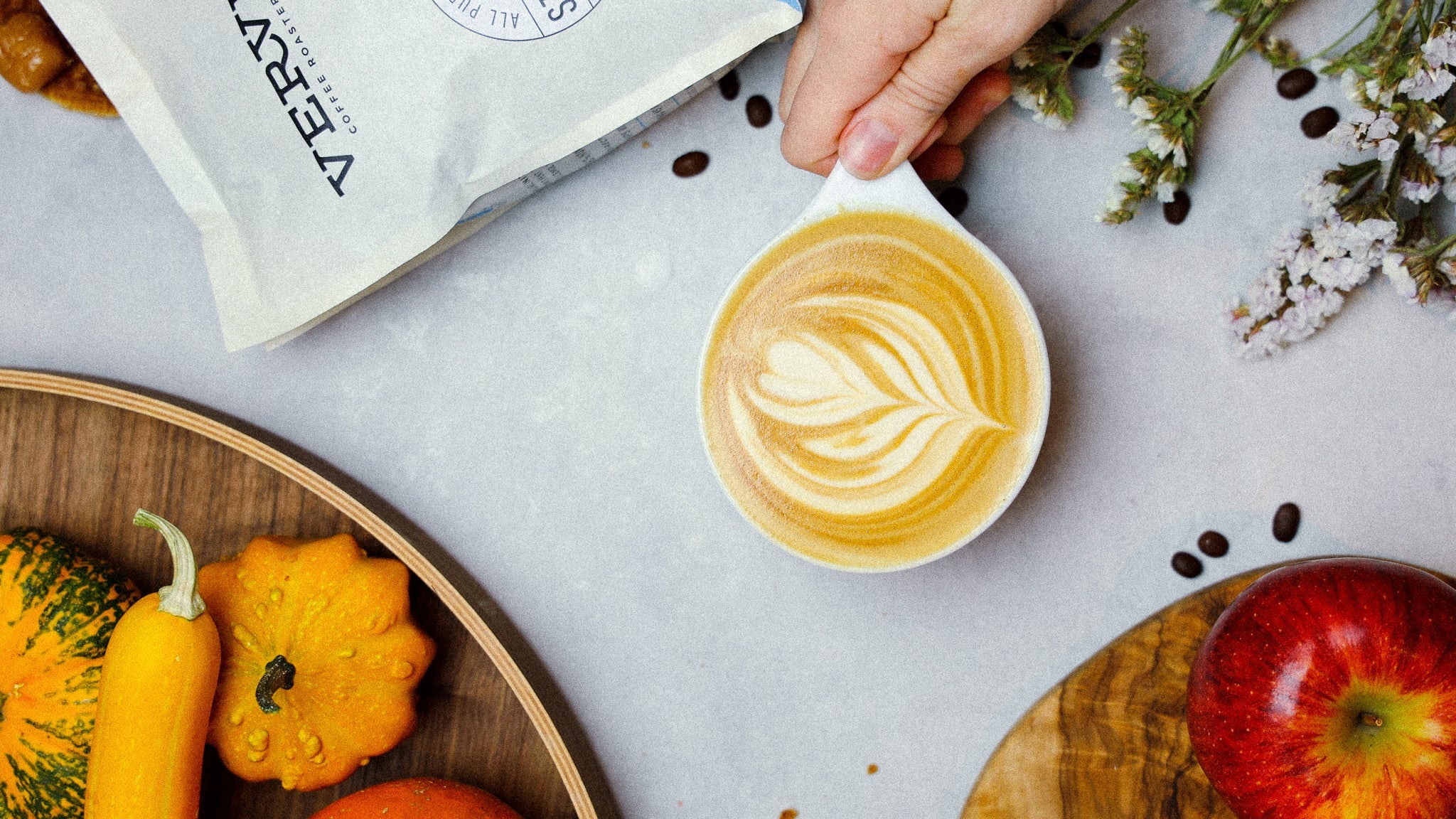 A latte with a festive fall spread.